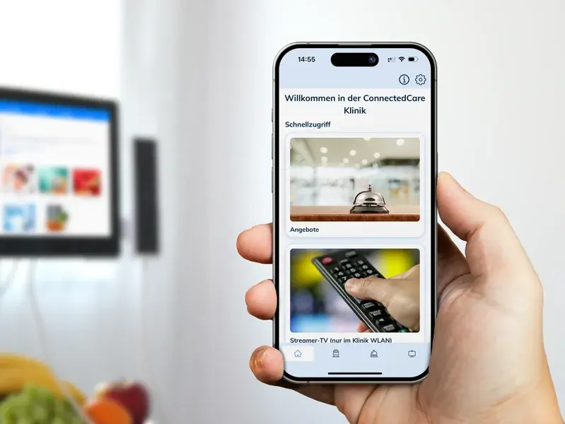 Ein Patient nutzt die BOYD-App mit seinem iPhone, während er in seinem Krankenbett liegt.