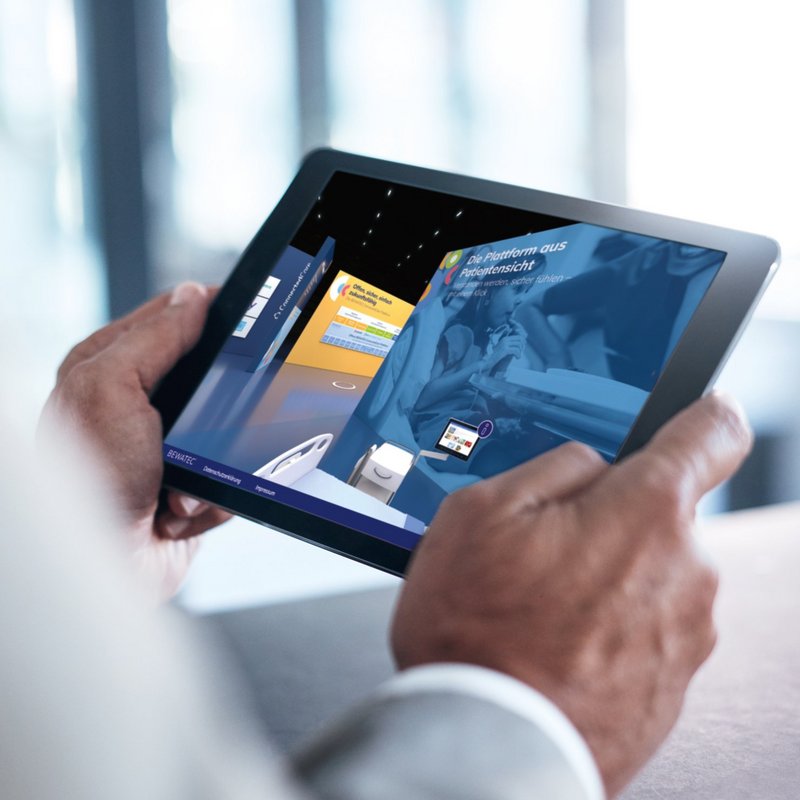 Mann hält Tablet mit ConnectedCare digitaler Showroom